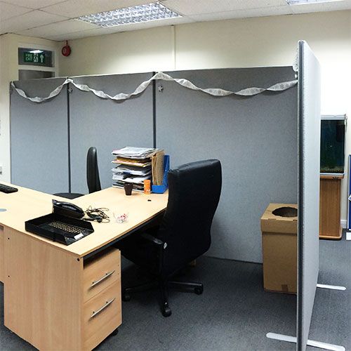 1800mm high Budget acoustic panels with grey fabric. Positioned behind desk for privacy. 