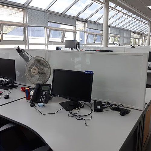 Easy clean, white gloss laminate desk divider attached to a desk in office setting