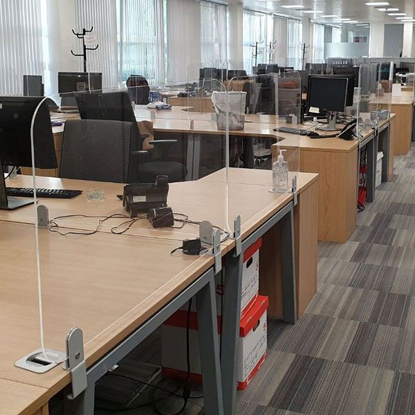 Perspex Desk Divider Screens positioned between office desks and used for social distancing