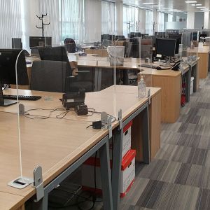 Perspex Desk Divider Screens positioned between office desks and used for social distancing